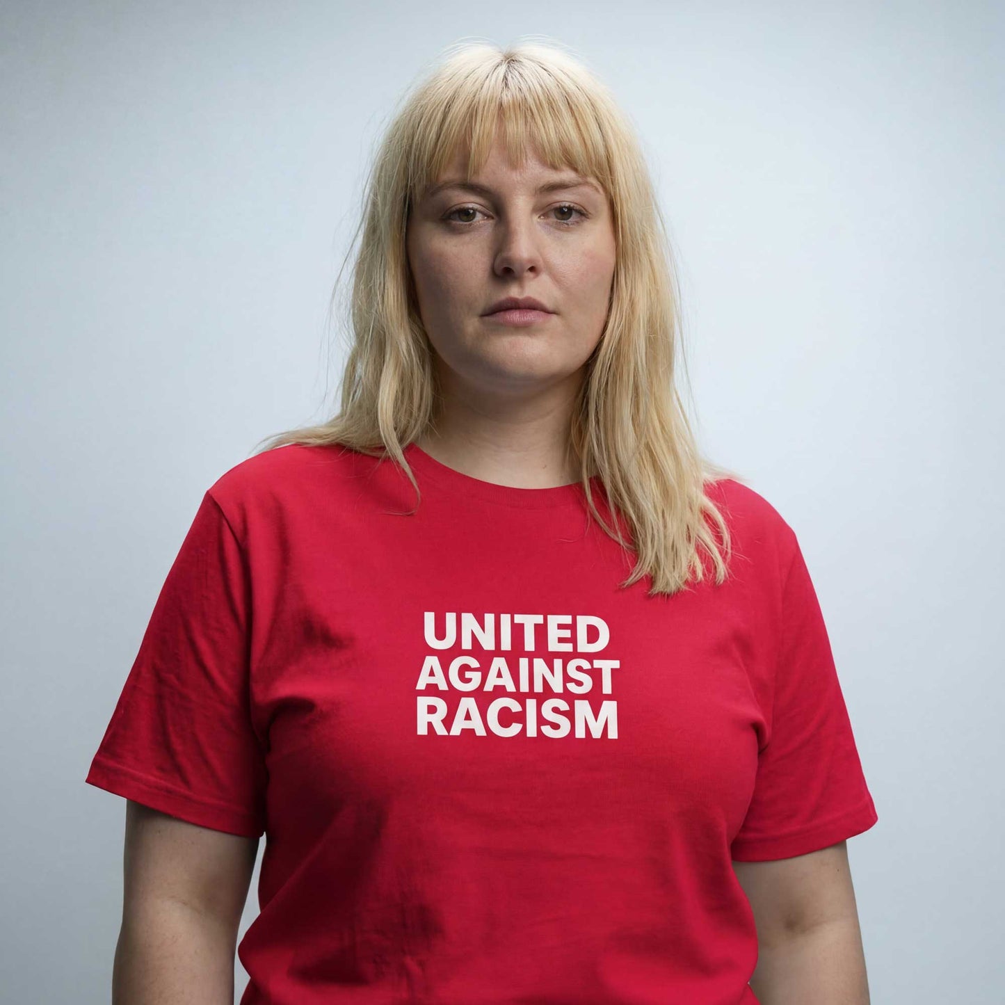 Woke United Against Racism red organic cotton t-shirt worn — lifestyle front view by Woke FC