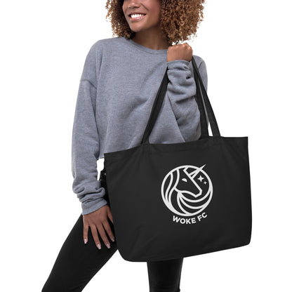 Model holding WOKE FC organic cotton unicorn black tote bag