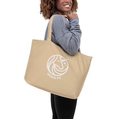 Model carrying WOKE FC organic cotton unicorn cream tote bag
